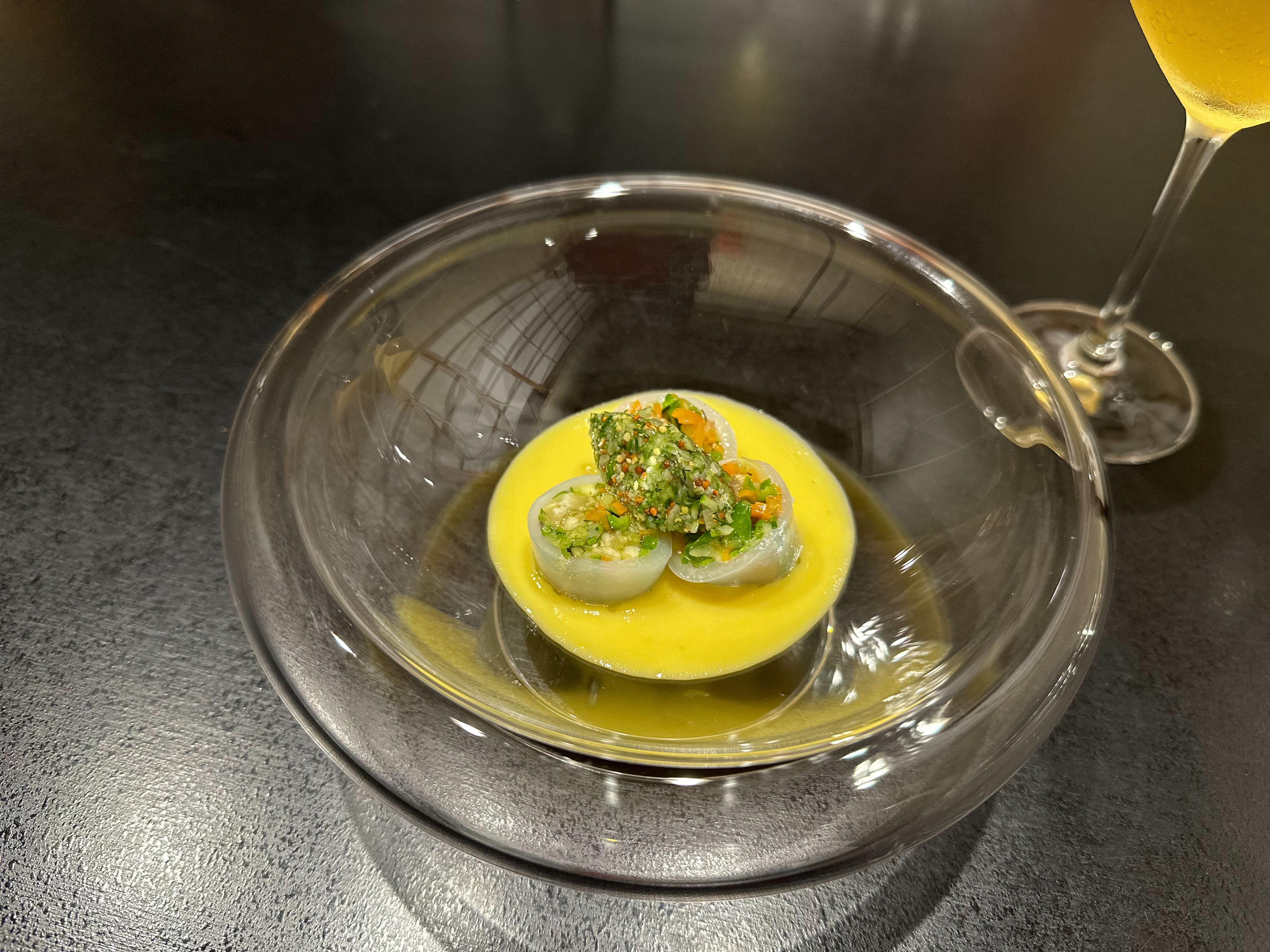ガラス皿に盛られた黄色いソースと緑の野菜の料理